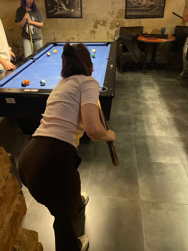 Woman plays pool in Budapest billiards room Friday evening