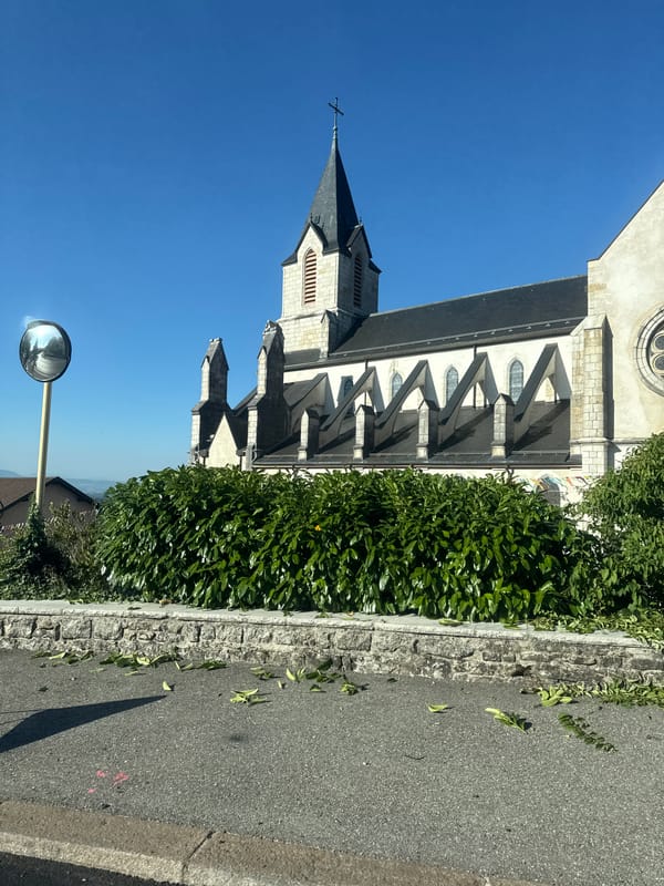 Church steeple and festive banners in central Gex, France