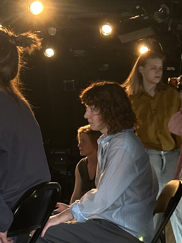 Young people gather in theater space for performance activity