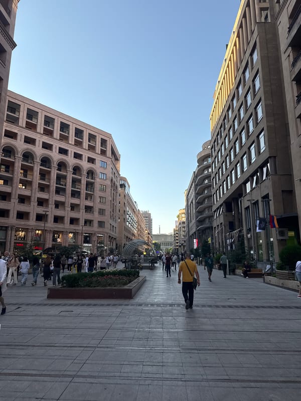 Street life, murals, and a busker in a busy urban district