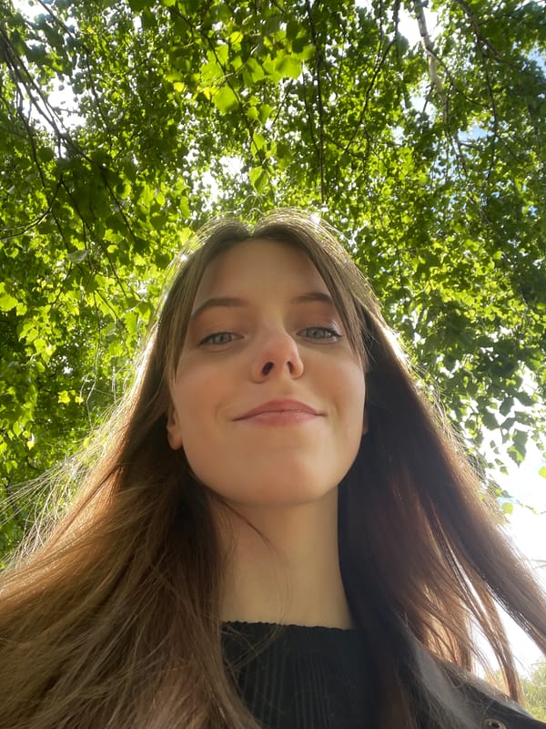 Young woman photographs herself near stone fence in Ufa