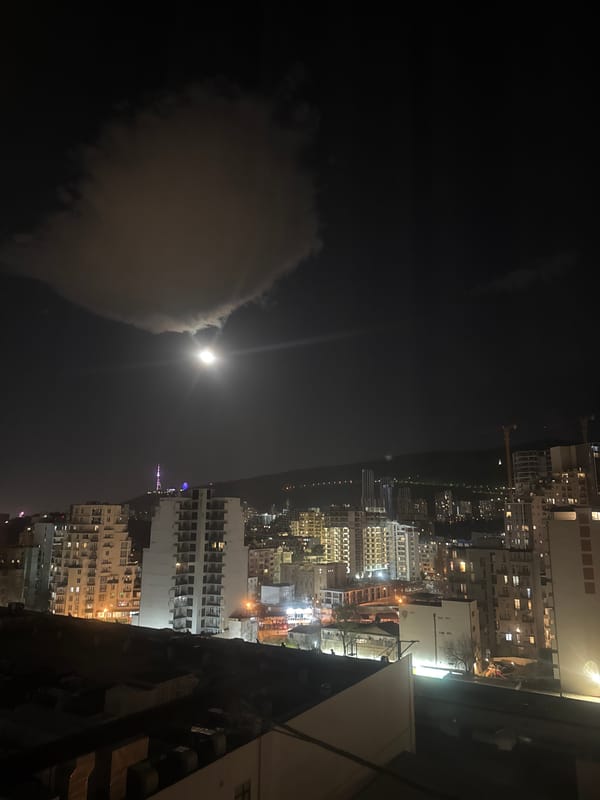 Tbilisi residents document moonlit cityscape during evening hours