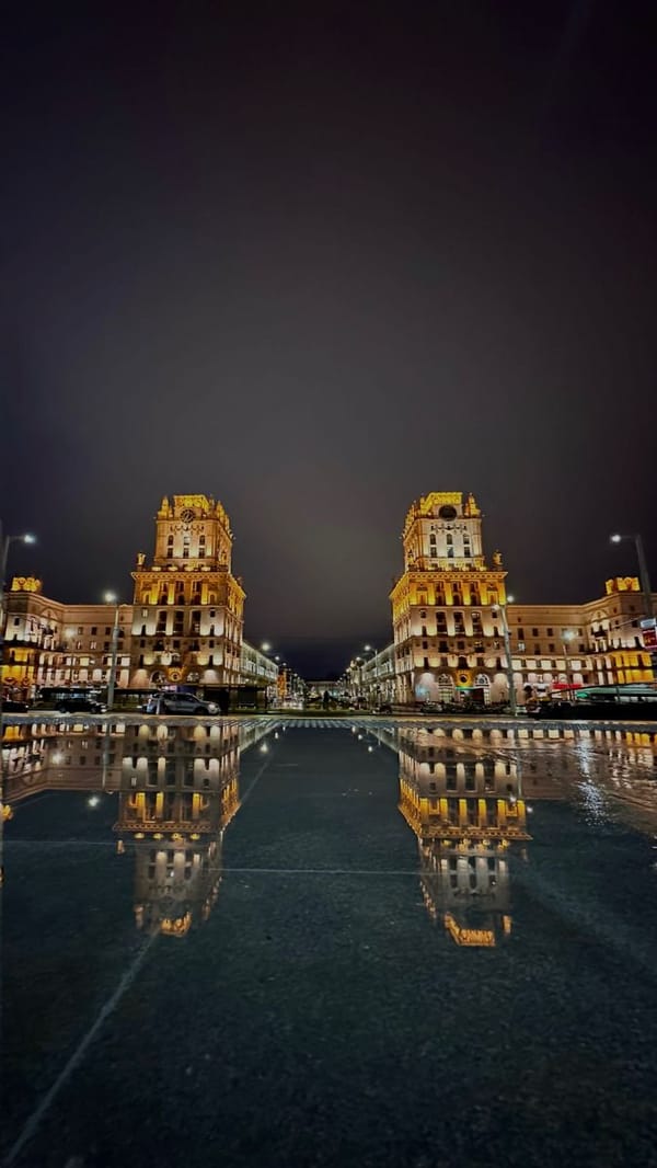 Golden-lit clock towers photographed in Minsk evening scene