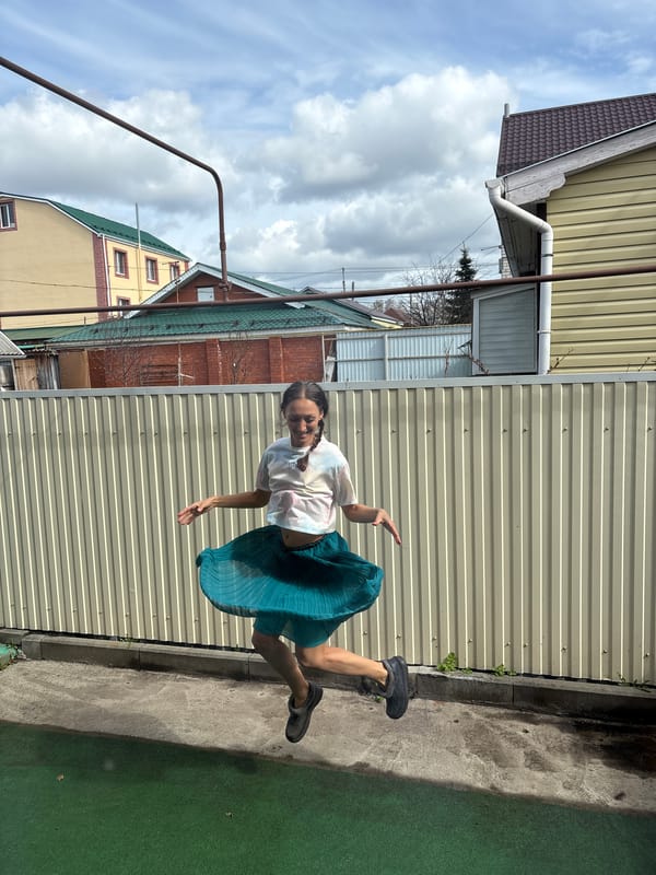Woman poses and gestures near fence in Ulyanovsk