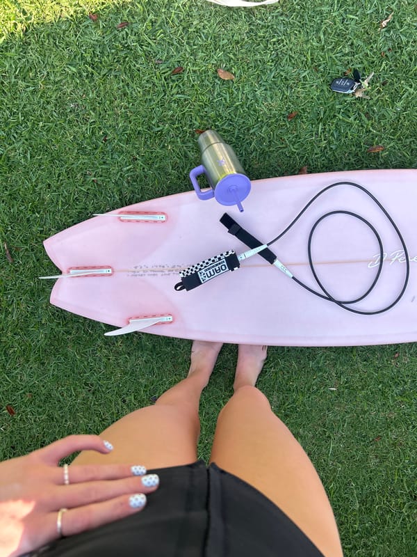 Pink surfboard with gear spotted on grass in Bulli