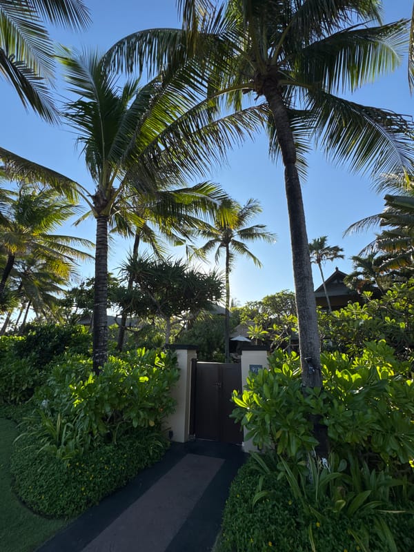 Indonesian beach scene documented with umbrellas, chairs, outrigger boats