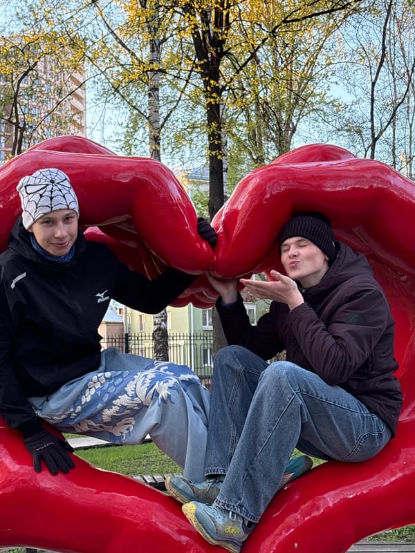 Visitors interact with red public art sculptures in Perm