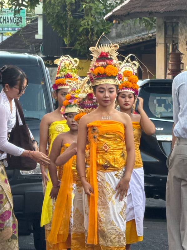 Traditional Balinese street performance with dancers, gamelan, and ceremony