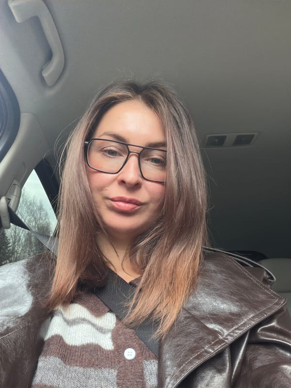 Woman takes selfies in car while passenger rests