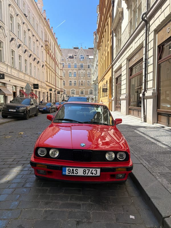 Tourist documents red BMW, landmarks in Prague Old Town