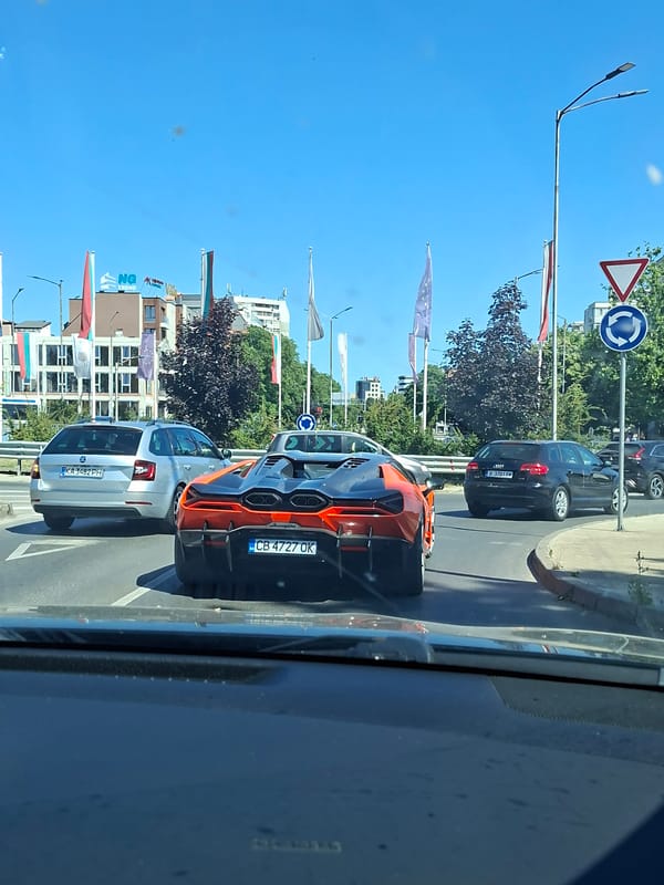 Orange sports car moving through sunny Varna streets