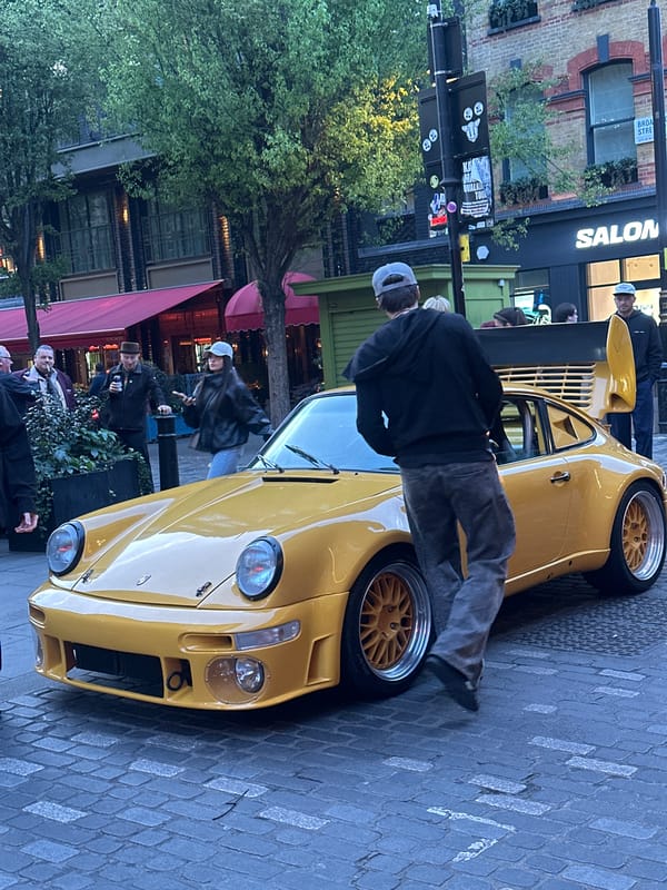 Yellow Porsche draws crowd on London cobblestone street