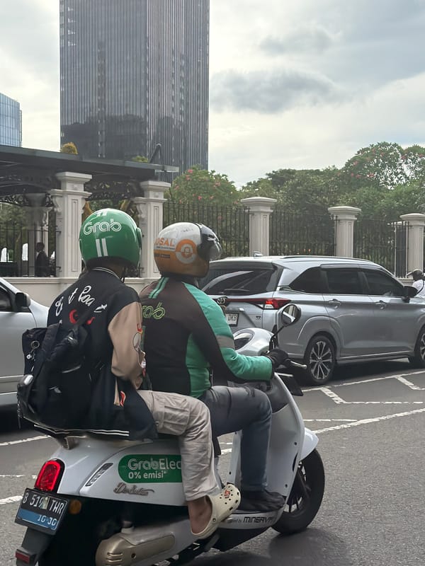 GrabBike drivers wait on Jakarta street amid overcast morning