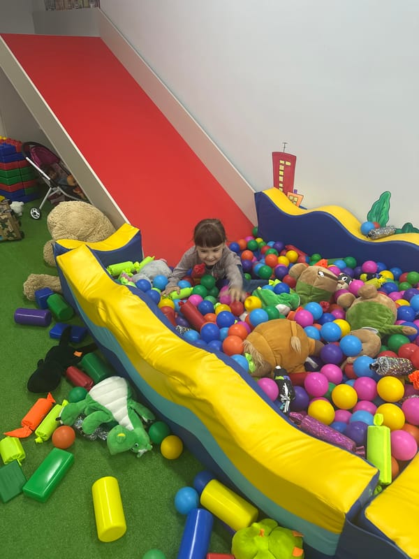 Children enjoy playtime with costumed entertainer at indoor venue