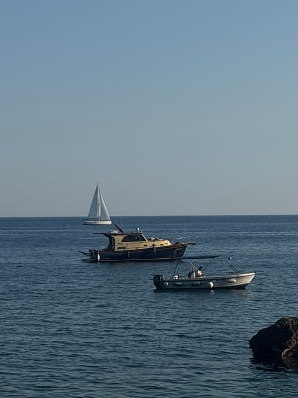 Sunny afternoon on the Montenegrin coast, boats and pebbled shores