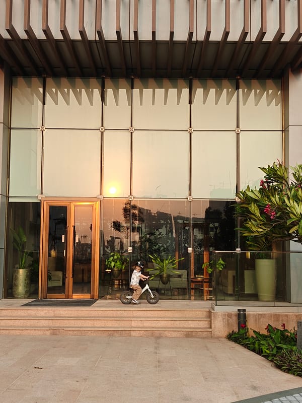 Child with bicycle spotted at modern Mumbai building terrace