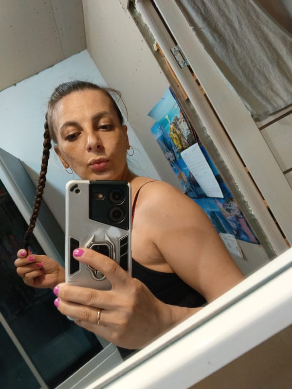 Woman takes selfies with orange cat at home