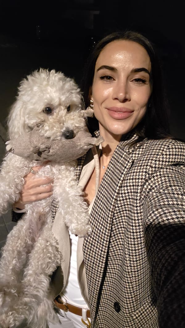 Woman poses with toy-carrying poodle in Lieli evening