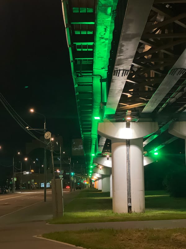 Green-lit Moscow overpass at night, with a street-level detail