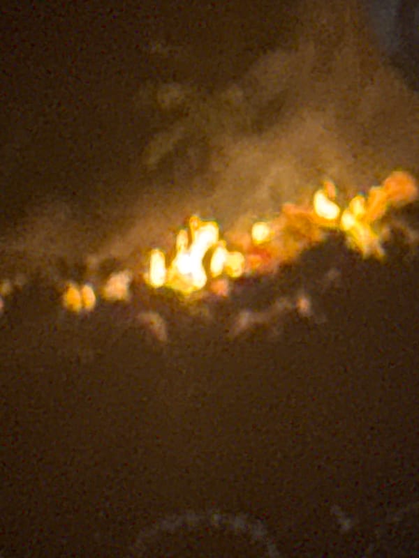 Nighttime hillside fire observed behind fence in Ihiagwa, Nigeria