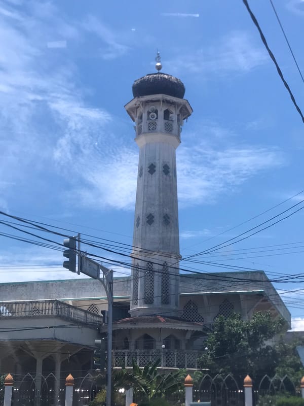 Mosque minaret photographed against blue sky in Lhokseumawe, Indonesia