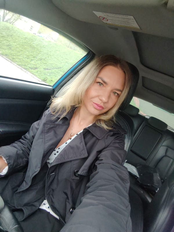 Woman takes selfie in car with subtle smile