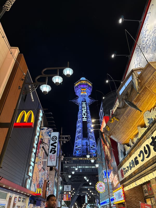 Nighttime photograph captures Osaka's illuminated signage and landmarks