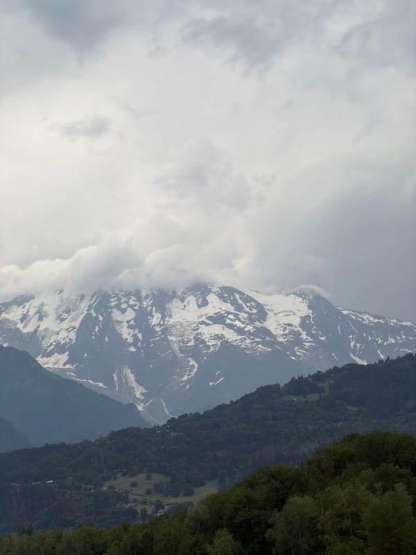 Snow-capped peaks and dark pines near Sallanches