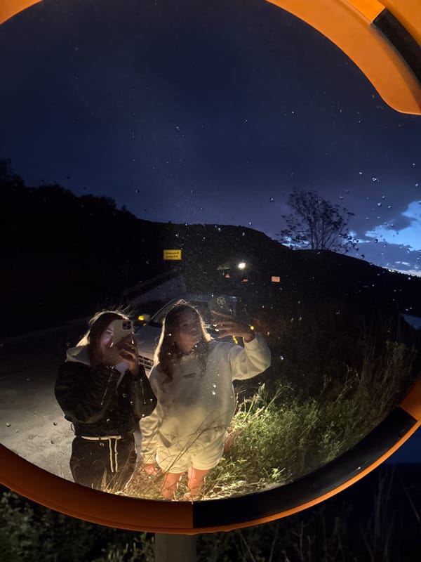 Young women photograph themselves in convex mirror in Montenegro