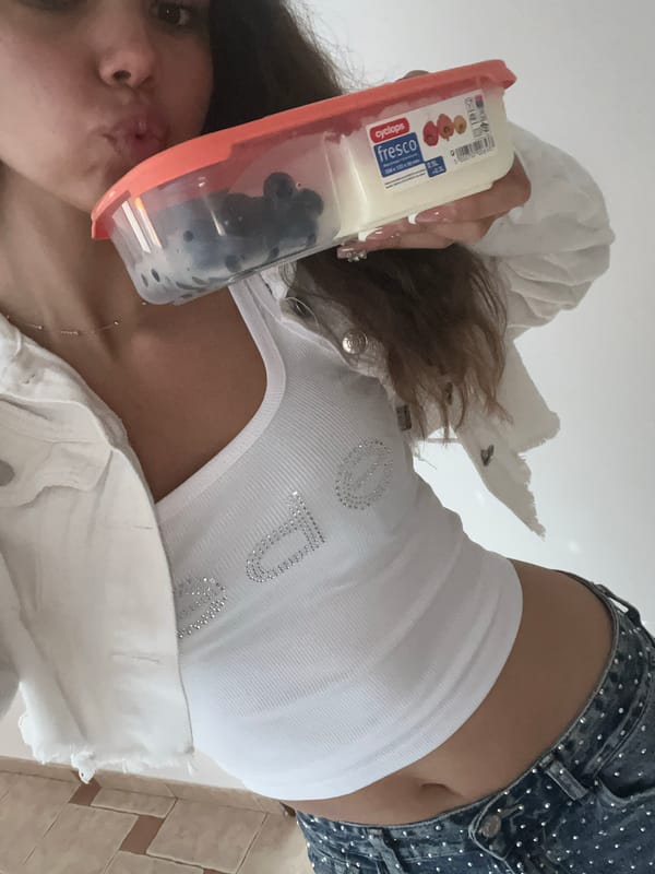 Woman takes multiple indoor selfies with food container