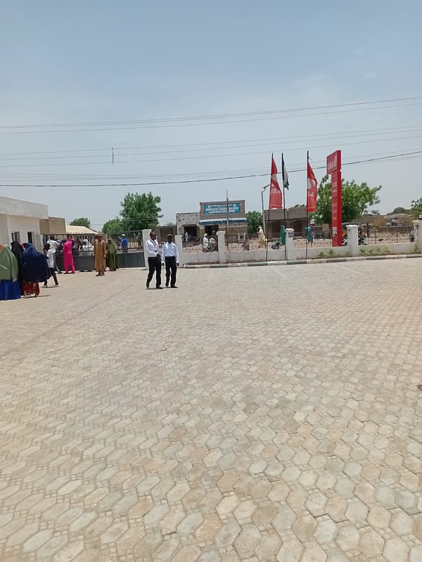 Men gather on tiled street in Dutsinma, Nigeria