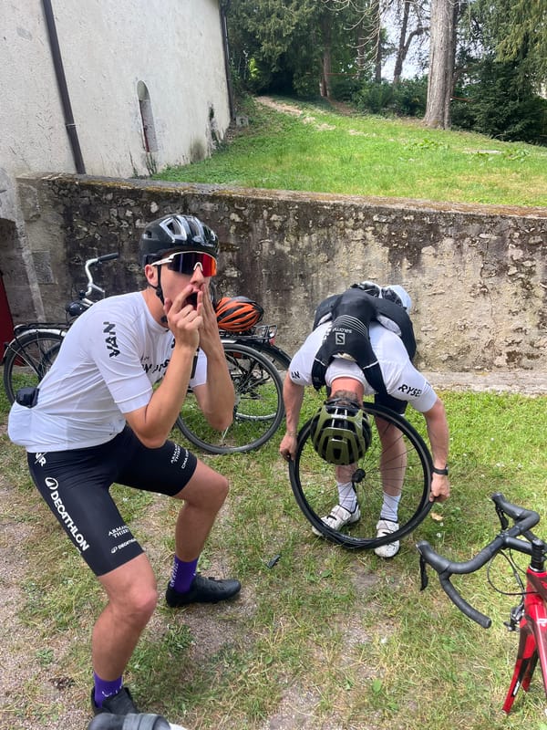 Cyclists perform roadside bike maintenance in Chambord, France