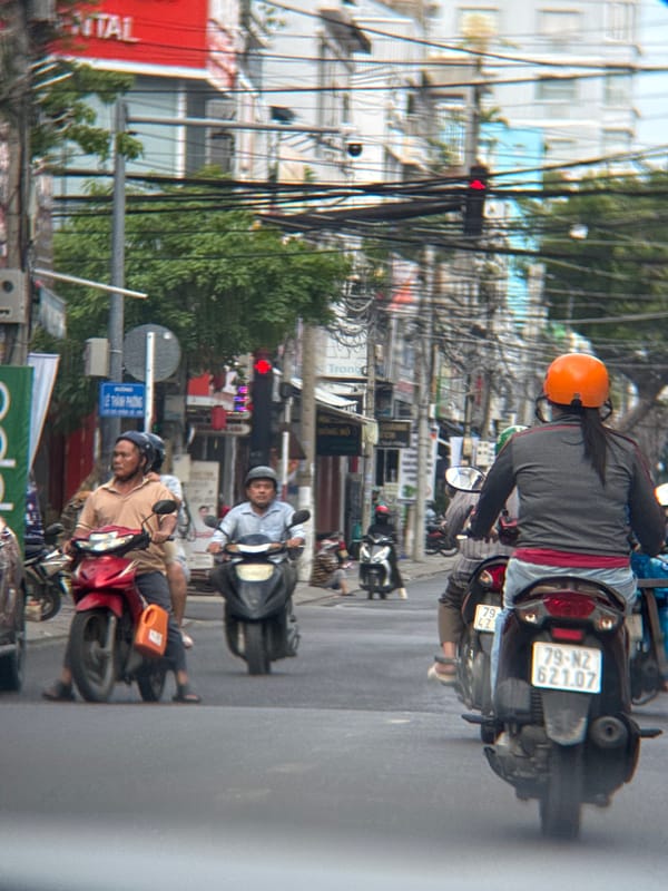 Morning motorbike traffic moves through a Nha Trang intersection