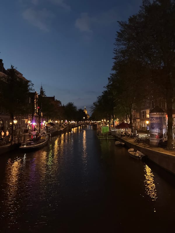 Amsterdam canals and storefronts at dusk, midsummer evening