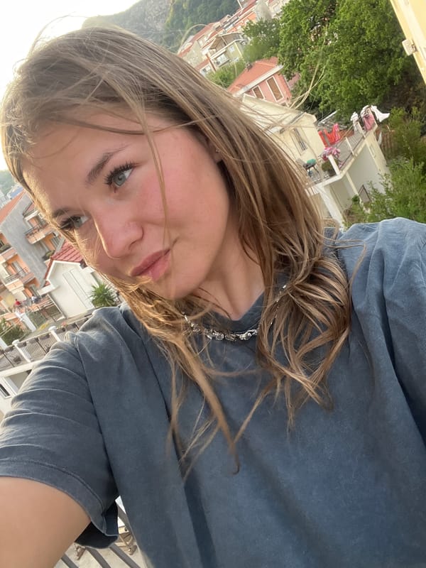 Tourist Takes Selfies Against Mountain Backdrop in Budva Montenegro