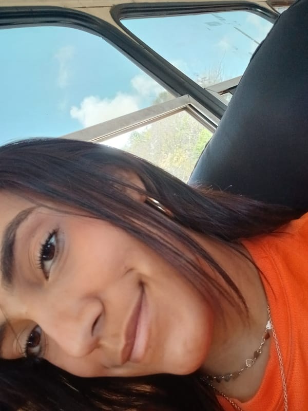 Woman in orange shirt photographed inside vehicle in Venezuela