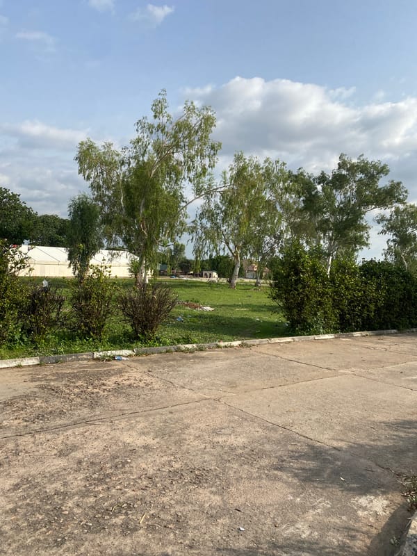 Weathered basketball court in Jalingo, Nigeria, on a clear afternoon