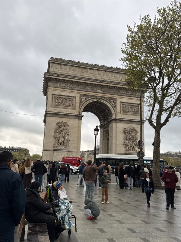 Tourists visit Arc de Triomphe under overcast Paris skies
