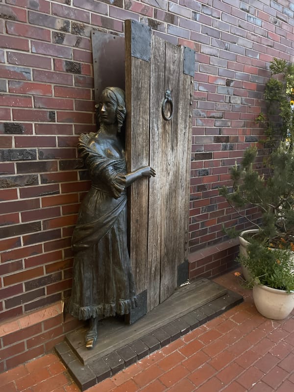 Woman interacts with bronze sculptures during evening stroll in Kaliningrad