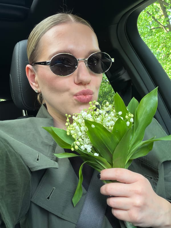 Woman with lily-of-the-valley bouquet observed in car, Riga