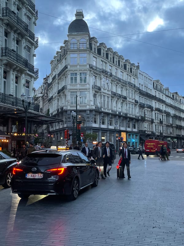 Evening street life captured around Brussels Bourse during twilight