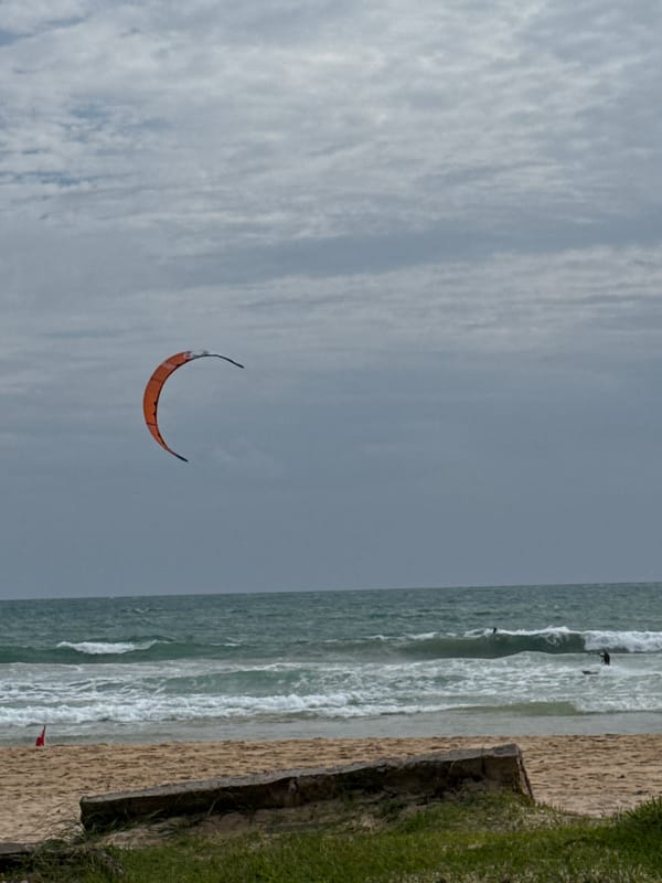 Overcast morning at Rawai Beach, kite flying, people relaxing