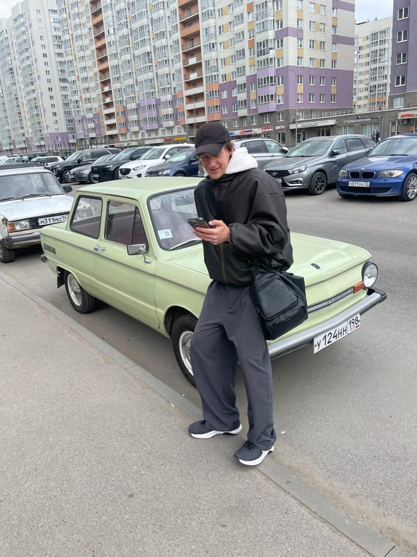 Man poses with vintage Soviet car on Russian street