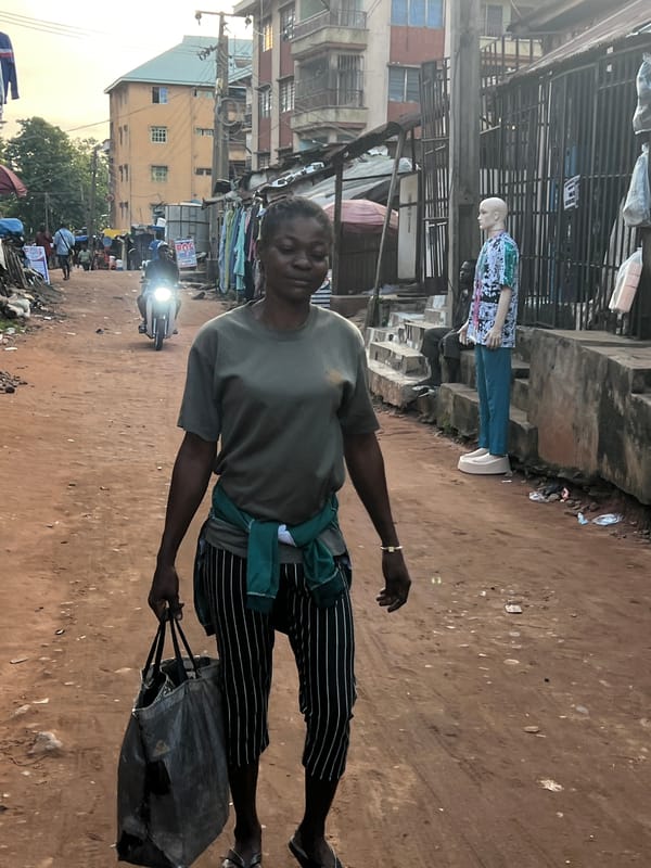 Afternoon foot traffic through Nkpor's busy market street.