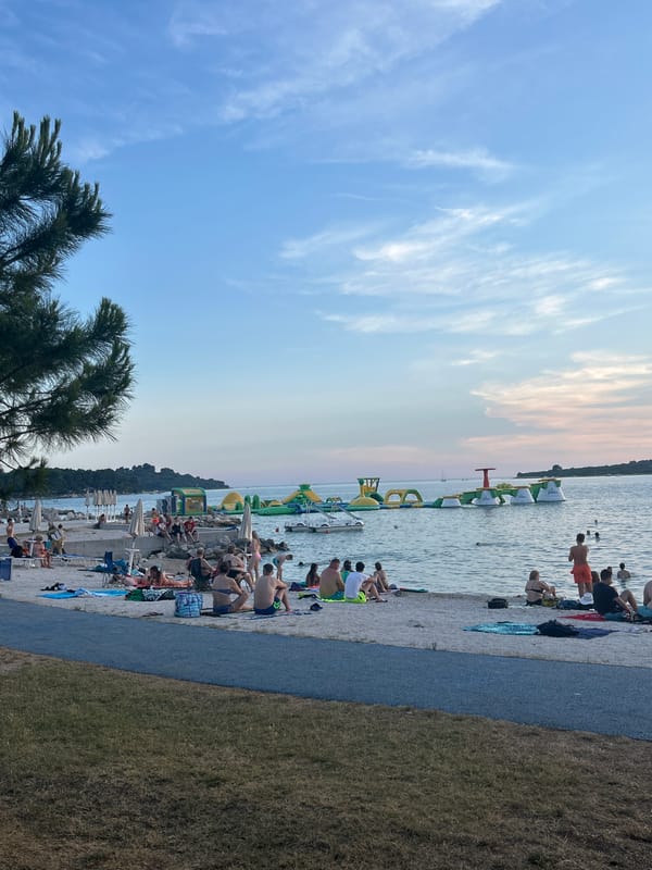 Sunset beach scene with people along the shore