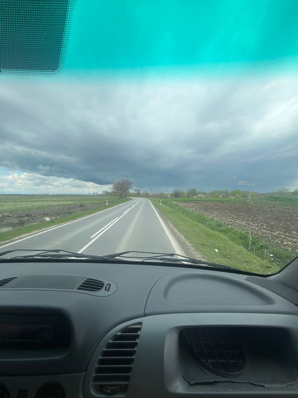 Vehicle travels rural road through Bulgarian countryside near Dalbok Izvor