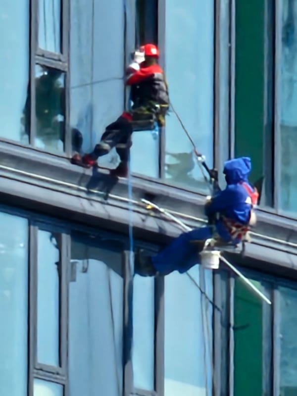Window cleaners work the glass exterior of a Moscow high-rise