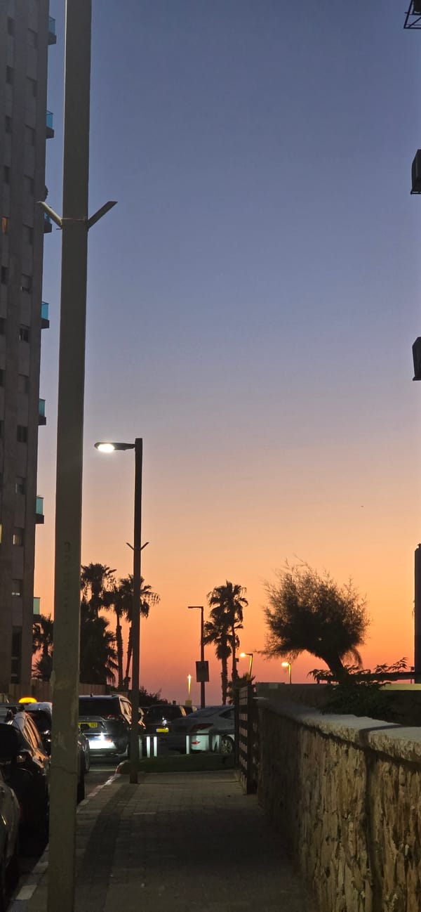 Bat Yam at dusk: tram, twilight skies, and city streets