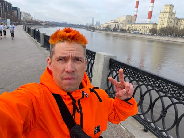 Man takes selfie on Moscow bridge while others walk riverside