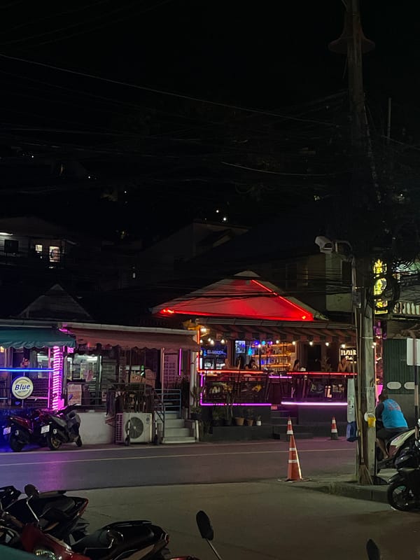 Neon nights, festival signage, and a dispensary shelf in Patong
